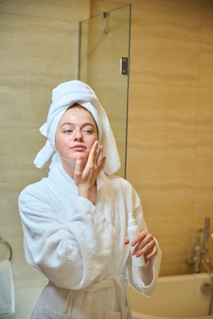 Donna che applica la crema sul viso