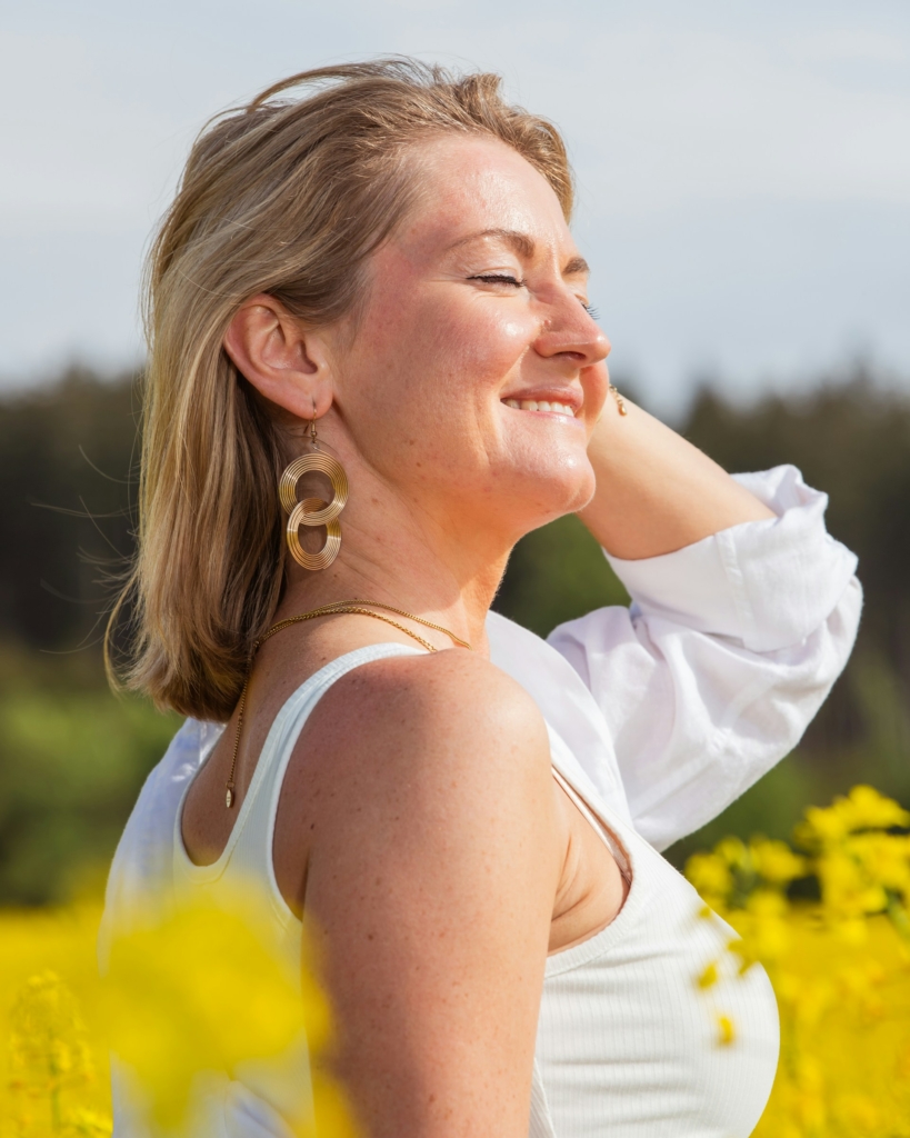 Középkorú szőke nő egy repceföldön