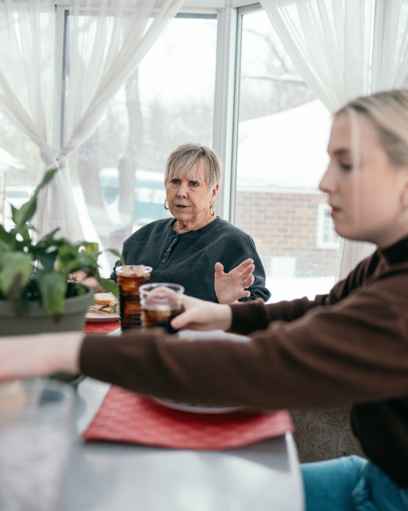 Nagymama és tini unokája ül az asztalnál
