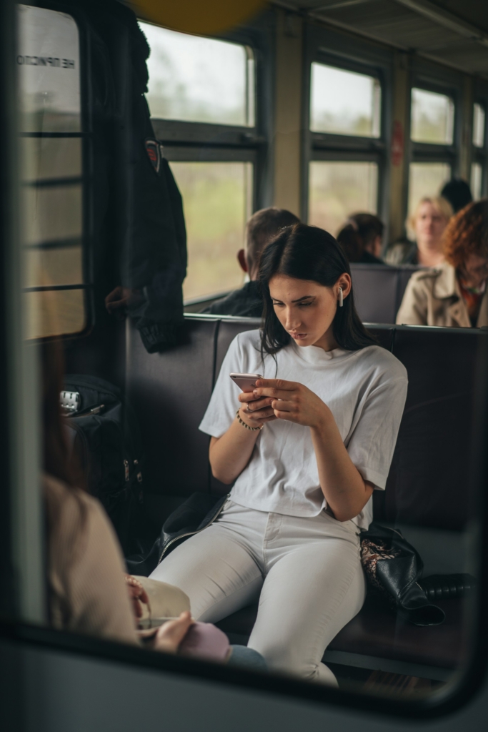 Nő a vonaton nézi a telefonját