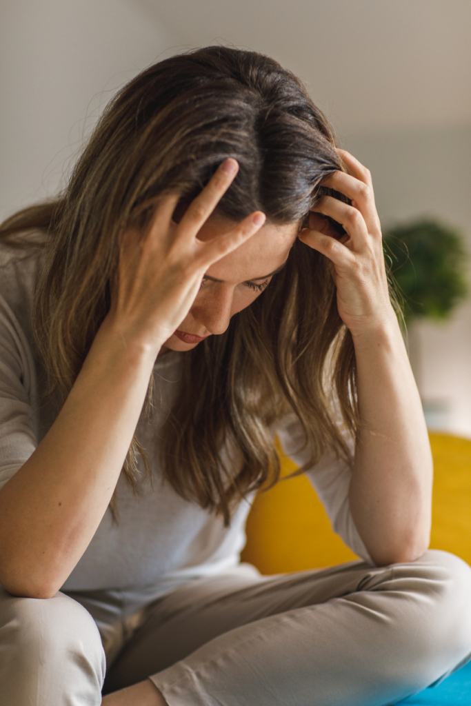 Stresszes nő fogja a fejét
