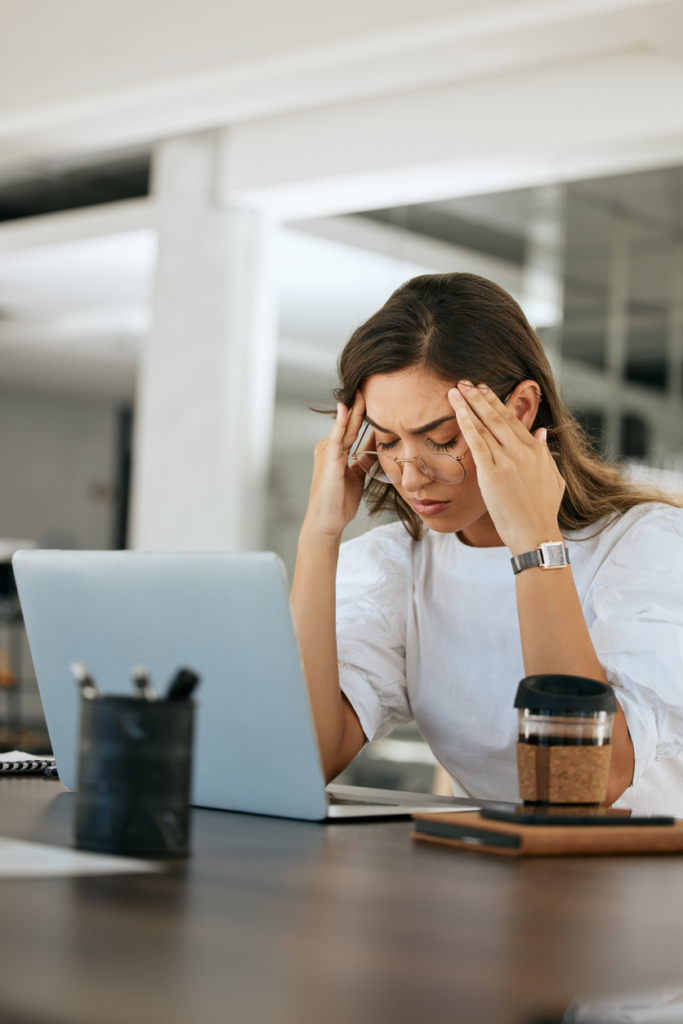 Stresszes dolgozó nő fogja a fejét