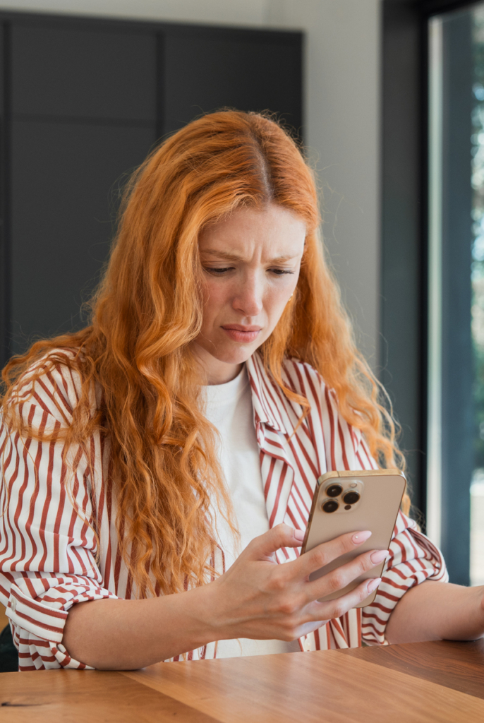 Nő feldúltan nézi a telefonját