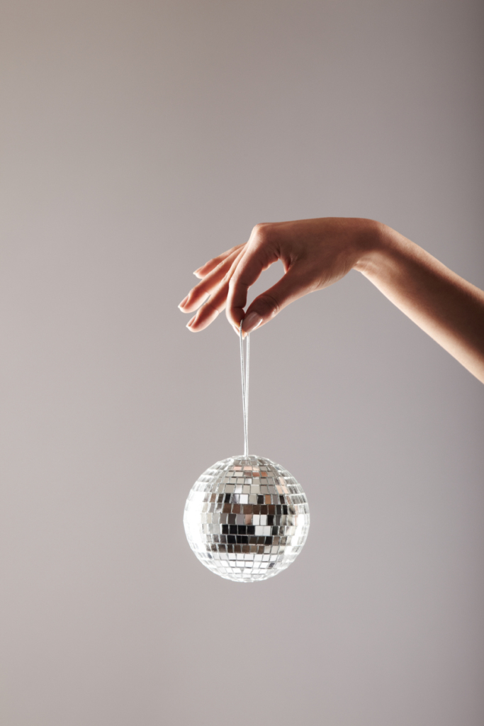 Női kéz egy kis disco-gömböt tart