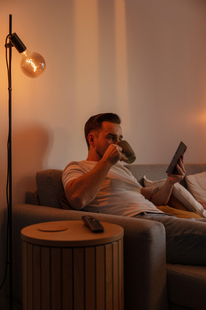 Férfi a tabletjét nézi a szoba sötétjében