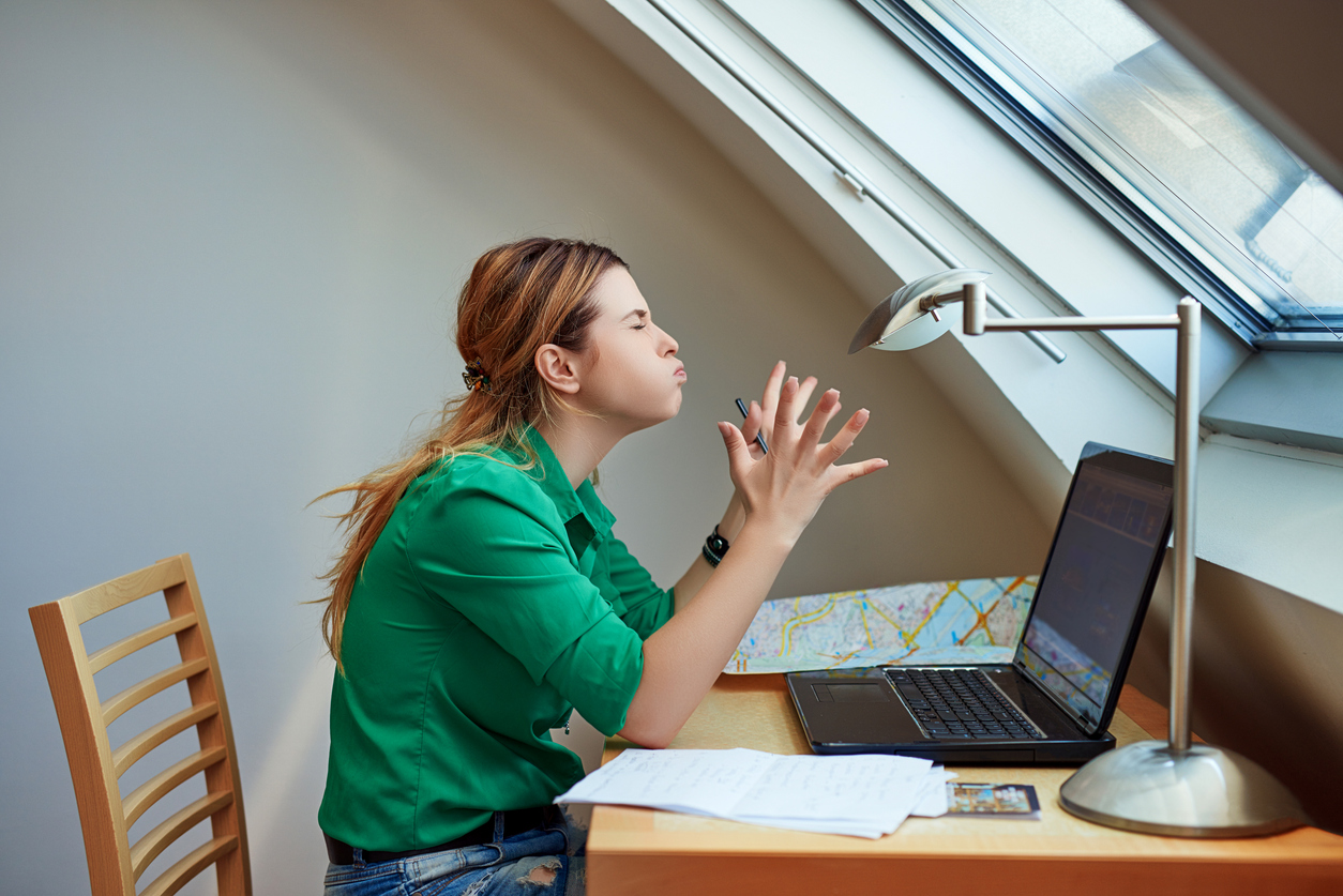 Dühös, ingerült nő a laptopja előtt bosszankodik
