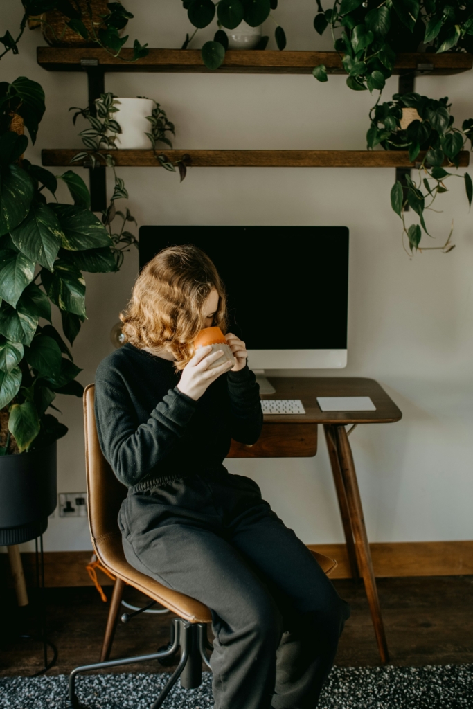 Nő home office-ban kávézik