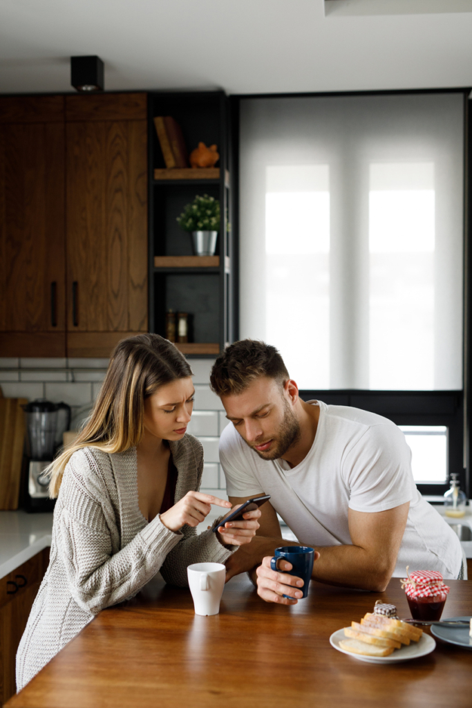 Pár együtt néz egy telefonon valamit