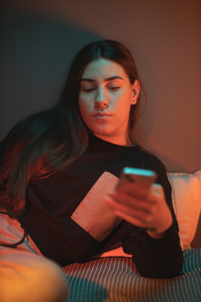 Szomorú tinilány görget a telefonján