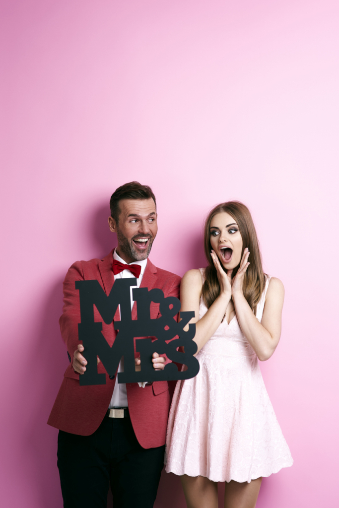 Pár egy Mr&Mrs táblát tart a kezében